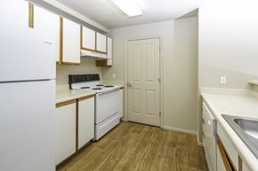 West Jordan apartment for rent - A kitchen with white appliances and wooden floors.at Sunset Ridge, West Jordan, UT