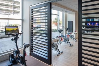 A gym with exercise bikes and a television.
