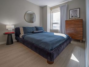 Washington apartment for rent - A bedroom with a large bed and a wooden headboard at Jayde Parkside Apartments, Washington DC