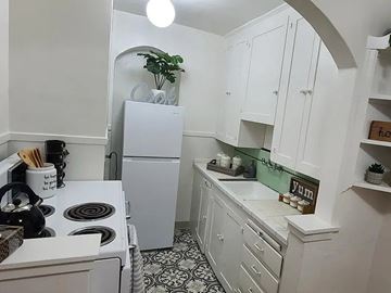Salt Lake City apartment for rent - A kitchen with white cabinets and a black and white floor.