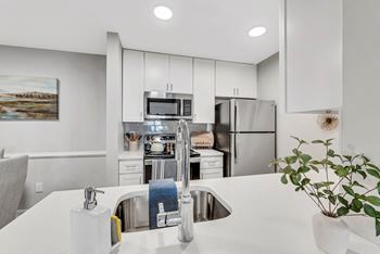 A kitchen with white cabinets and stainless steel appliances