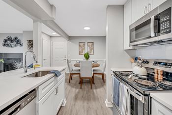 A kitchen with white cabinetry and stainless steel appliances