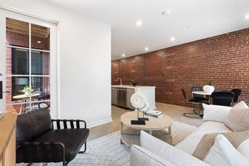 Washington apartment for rent - A living room with a black leather chair and a white couch.