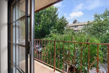 Hollywood multi-family for rent - A balcony with a metal railing and a view of a green tree and a building.