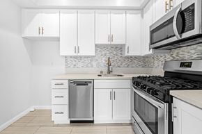 Los Angeles multi-family for rent - a white kitchen with stainless steel appliances and white cabinets at Hollywood Vista in Los Angeles, CA