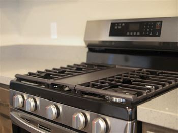 A stainless steel stove top oven sitting next to a counter