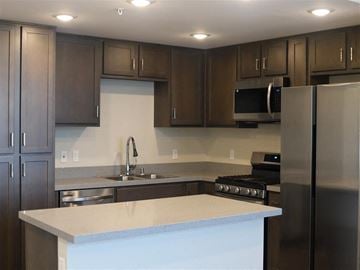 San Bernardino multi-family for rent - A kitchen with a white counter top and stainless steel appliances.
