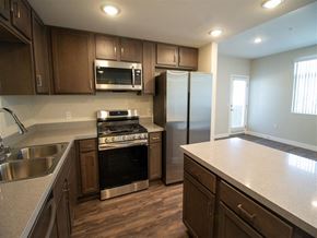 San Bernardino multi-family for rent - a kitchen with wooden cabinets and stainless steel appliances at Loma Villas Apartments, San Bernardino, California