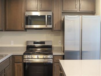A kitchen with a stove refrigerator and microwave