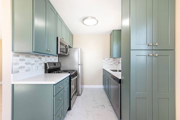 Hollywood multi-family for rent - A kitchen with green cabinets and a white counter.