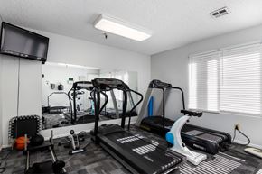 Lakewood apartment for rent - A home gym with a treadmill, exercise bike, and other equipment. at Whispering Fountains Lakewood, California