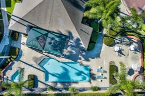 Lakewood apartment for rent - An aerial view of a house with a pool and a patio area. at Whispering Fountains Lakewood, Lakewood Bar, CA