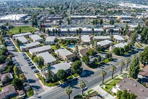 Riverside apartment for rent - Suburban area with apartment buildings and palm trees at Whispering Fountains Riverside, Riverside, CA, 92503