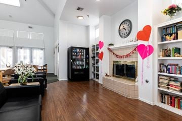 Whittier apartment for rent - A living room with a black couch and a fireplace.