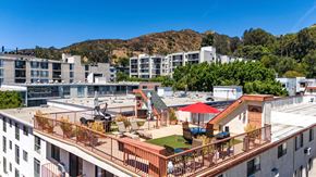 Hollywood multi-family for rent - Rooftop terrace with seating and mountain backdrop at Joro Properties Apartments, California