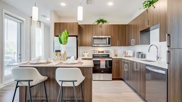Centennial apartment for rent - A modern kitchen with a dining table set for two.
