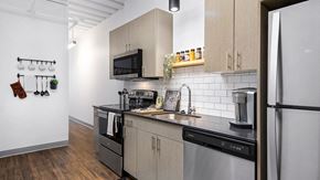 Chicago apartment for rent - Looking along the kitchen counter in a residence at Wrigleyville lofts. Stainless steel appliances are set along the cabinets.