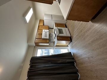 Fort Collins apartment for rent - A view of a staircase leading to a kitchen area with a window.