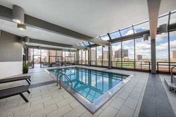 A swimming pool on the top of a building with a city view