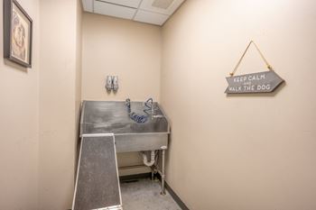 A laundry room with a sink and a sign on the wall