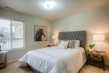 Richland multi-family for rent - A bedroom with a large bed and a painting of a horse on the wall.