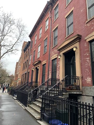 Brooklyn apartment for rent - a row of red brick buildings on a city street