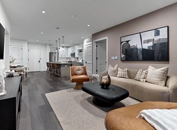 Paramus apartment for rent - A modern living room with a black coffee table and a brown leather chair.