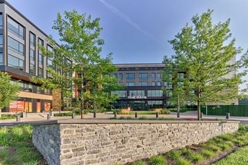 New Brunswick apartment for rent - A modern building with a stone wall in front of it.