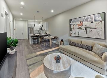 East Brunswick apartment for rent - A modern living room with a grey couch and a large abstract painting on the wall.