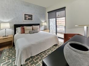 Hackettstown apartment for rent - A bedroom with a large bed and a grey vase on a table.