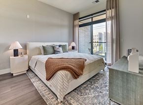 Orange apartment for rent - A bedroom with a large bed and a window.