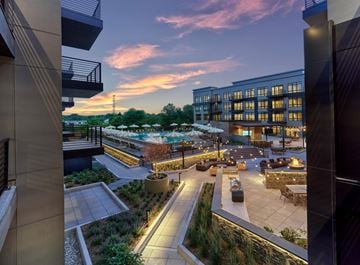 Paramus apartment for rent - A modern building with a rooftop terrace and a garden area.
