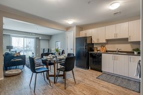 Sylvan Lake apartment for rent - A kitchen with a black refrigerator and wooden floors.