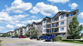 Winnipeg apartment for rent - A row of apartment buildings with cars parked in front.