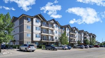 Winnipeg apartment for rent - A row of modern apartment buildings with cars parked in front.