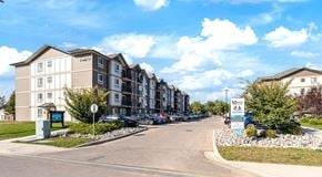 Portage La Prairie apartment for rent - A row of apartment buildings with cars parked in front.