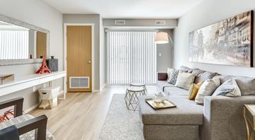 Saskatoon apartment for rent - A living room with a grey couch, a coffee table, and a painting on the wall.