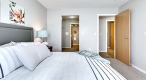 Saskatoon apartment for rent - A bedroom with queen sized bed with a walk in closet leading to a ensuite bathroom