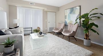 Edmonton apartment for rent - A living room with a white sofa, a glass coffee table, and a large painting on the wall.