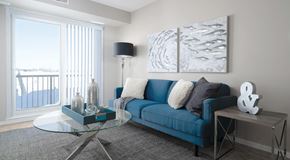 Winnipeg apartment for rent - a living room with couch, coffee table, end table and lamp. Large glass sliding door leading to balcony
