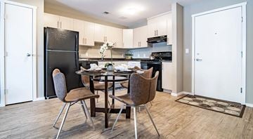 Red Deer apartment for rent - A kitchen with a table and chairs in the middle.