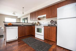 Winnipeg apartment for rent - A kitchen with wooden cabinets and white appliances.