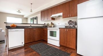 Winnipeg apartment for rent - A kitchen with white appliances and wooden cabinets.
