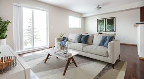 Winnipeg apartment for rent - A living room with a couch, coffee table, and large sliding glass door