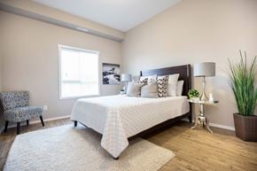 Saskatoon apartment for rent - A bedroom with a large bed and a chair.