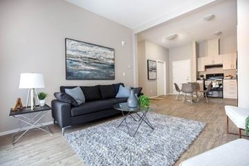 Saskatoon apartment for rent - A living room with a grey couch, a coffee table, and a painting on the wall.