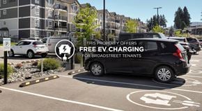 Saskatoon apartment for rent - A parking lot with a sign offering free EV charging for brook street tenants.