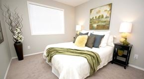 Edmonton apartment for rent - A bedroom with queen sized bed and two nightstands. a large window with blinds on one wall