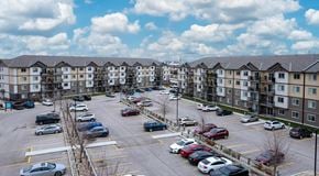 Winnipeg apartment for rent - A large apartment complex with a large parking lot in front
