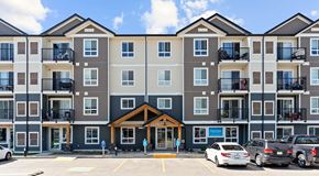 Saskatoon apartment for rent - A large apartment building with a parking lot in front.